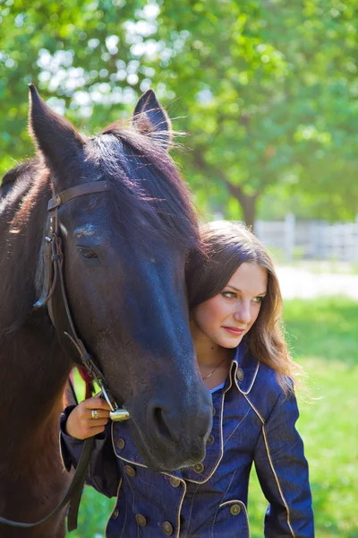 Jovem caminhando com um cavalo no jardim . — Fotografia de Stock