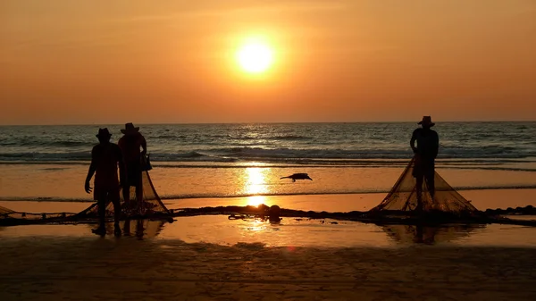 Rybacy przeciągnięty na brzeg sieć. zachód słońca, Morza Arabskiego. — Zdjęcie stockowe