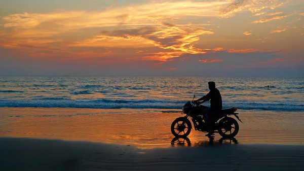 Motorcyclist at sunset on the beach. Abstract background "lifest — Stock Photo, Image