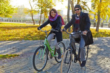 genç bir çift sonbahar park bir bisiklet sürme