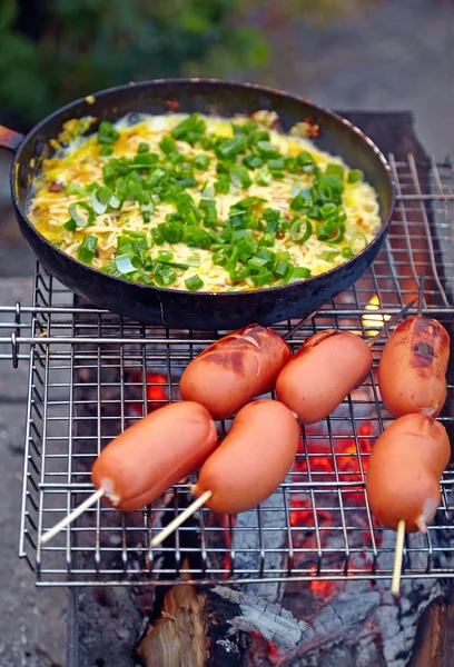Смажені ковбаски та яйця, приготовані на вогні . — стокове фото