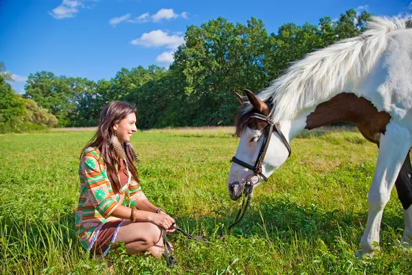 A young girl dressed as an Indian walking with a paint horse — Stok fotoğraf