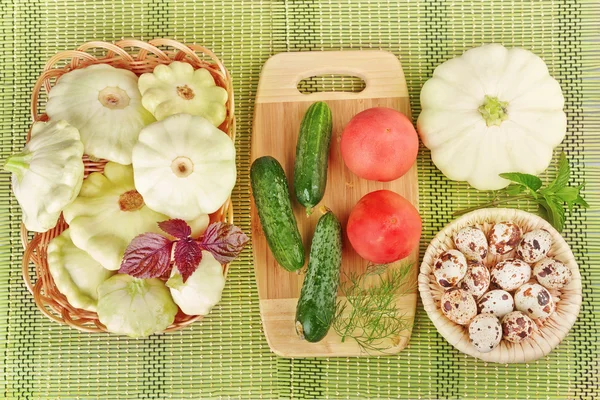 Grønnsaker og vaktelegg i kurv med grønn bakgrunn – stockfoto