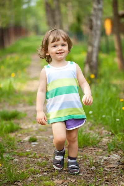 Happy boy walking on path in park — Stock Photo, Image