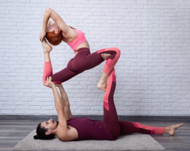 Genç çift evde akro yoga kralı güvercin pozuyla eğleniyor..