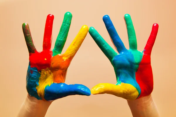 Malowane ręce, kolorowe zabawy. pomarańczowe tło — Zdjęcie stockowe