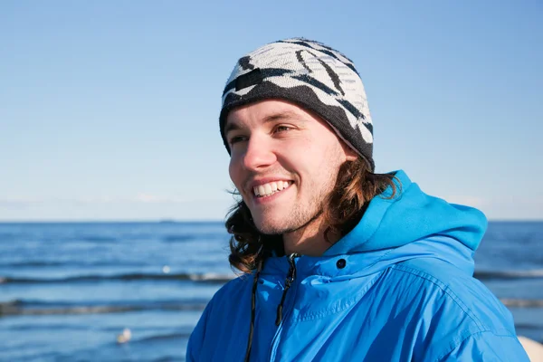 Jovem retrato de homem feliz na praia. Dia ensolarado frio — Fotografia de Stock