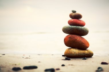 Stones pyramid on sand symbolizing zen, harmony, balance clipart