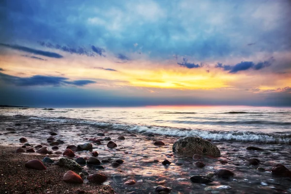 Dramatyczne wschód na kamienistej plaży. Morze Bałtyckie — Zdjęcie stockowe