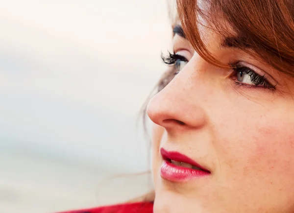 Mujer joven y bonita mirando el océano de una manera romántica — Foto de Stock