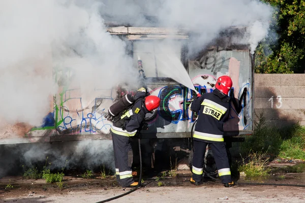 Firefighters fighting a fire of a waste place — Stock Photo, Image