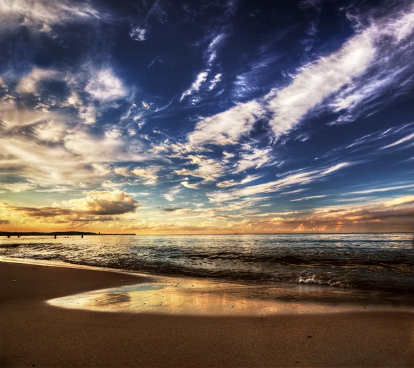 平静海洋戏剧性落日的天空下 — 图库照片