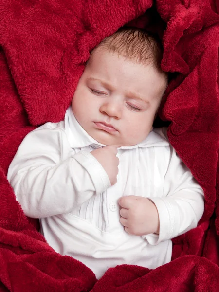 Lovely 3 months baby sleeping on bed covered with red blanket — Stock Photo, Image