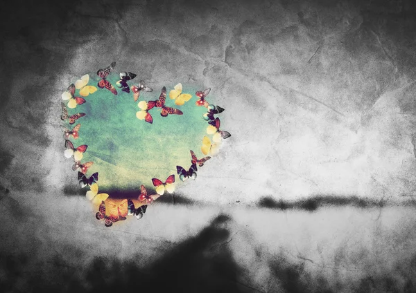 Форма сердца из разноцветных бабочек на черно-белом поле — стоковое фото