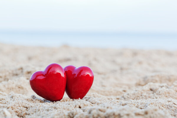 Deux cœurs rouges sur la plage symbolisant l'amour, Saint Valentin, couple romantique — Photo