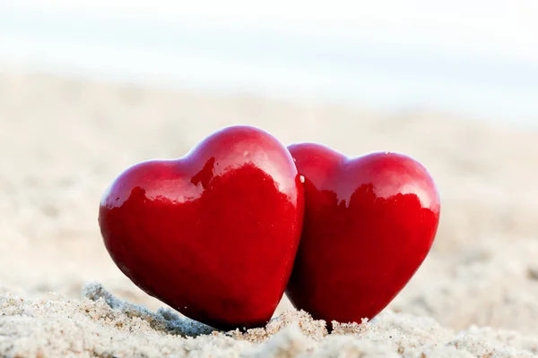 Dos corazones rojos en la playa que simbolizan el amor, Día de San Valentín, pareja romántica — Foto de Stock