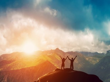 A happy couple on the peak of a mountain clipart