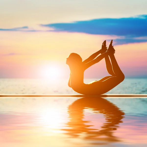 En silhuett av en kvinna i fören yoga position — Stockfoto