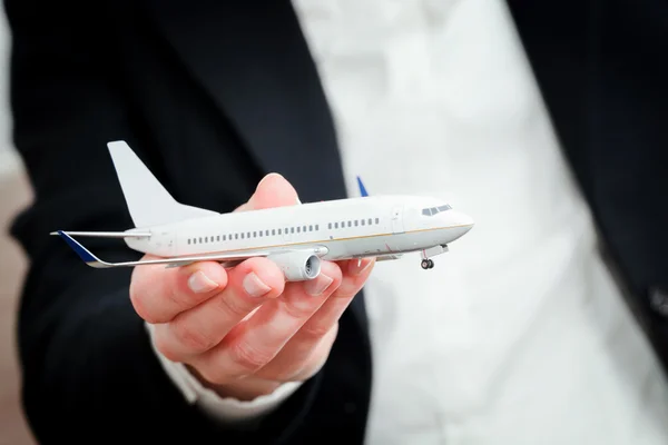 Persona de negocios que sostiene el modelo de avión — Foto de Stock