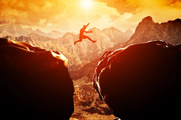 Man jumping over precipice Stock Photo