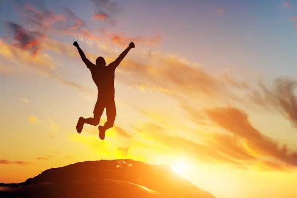 Man springen van vreugde op de top van de berg — Stockfoto