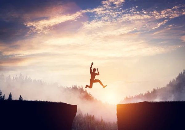 Mann Springt Bei Sonnenuntergang Zwischen Klippen Waldhügel Hintergrund — Stockfoto