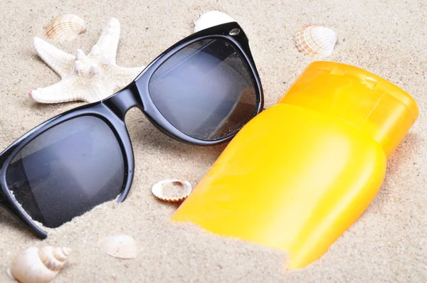 Sun protection and sunglasses on a beach — Stock Photo, Image