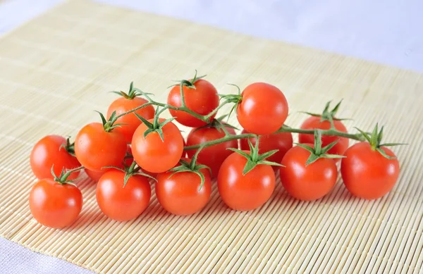 Tomates cereja frescos em fundo de bambu — Fotografia de Stock