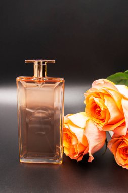 Bir parfüm şişesi, yanında bir gül çiçeği, sevdiklerimiz için şenlikli bir hediye..