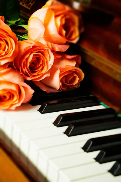 Bouquet of pink roses on the piano keyboard, romantic atmosphere. A gift from fans. Stock Photo