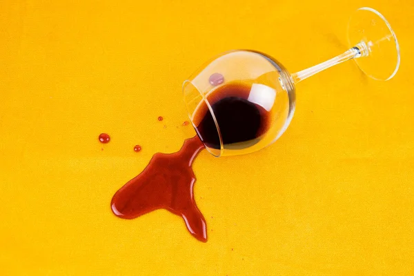 A spilled glass of wine on the tablecloth. Cleaning clothes and furniture from stains. Stock Image