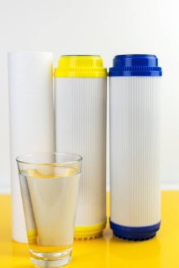 Su arıtma filtresinin yanında bir bardak temiz su. Ev filtreleme sistemi kavramı