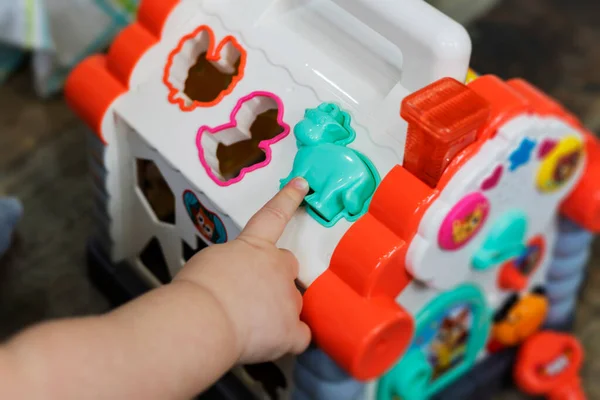 Barnet leker med färgglada leksaksfigurer. Utbildningsspel för barn. — Stockfoto