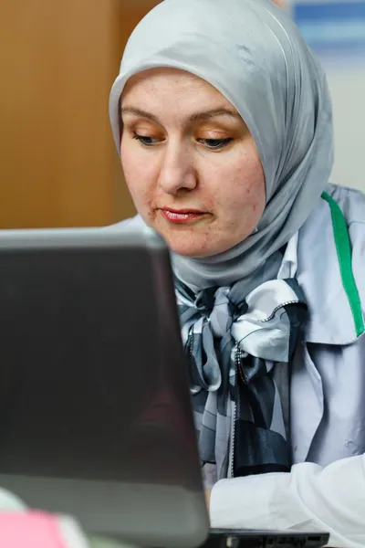 Mulher muçulmana jovem bonita usando laptop no escritório — Fotografia de Stock