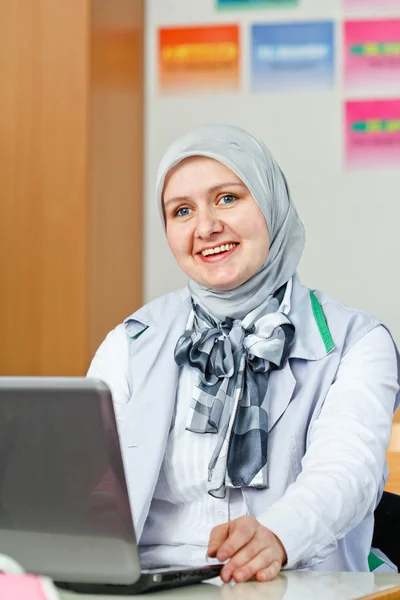 사무실에서 노트북을 사용 하 여 아름 다운 젊은 무슬림 여성 스톡 이미지