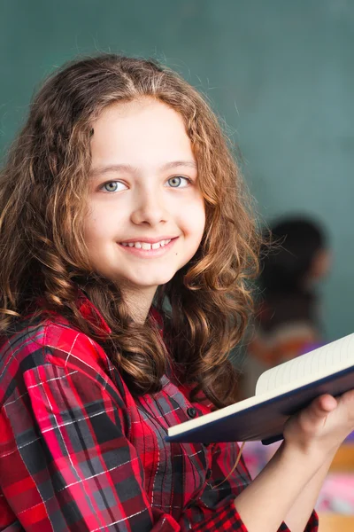 Söt skolflicka håller en bok — Stockfoto