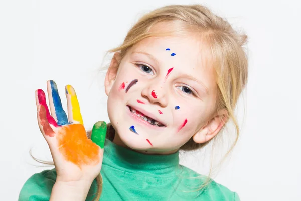 Маленькая забавная девочка с раскрашенными руками и лицом — стоковое фото