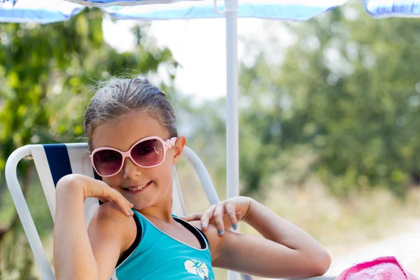 Feliz niña sentada en char en un día soleado —  Fotos de Stock