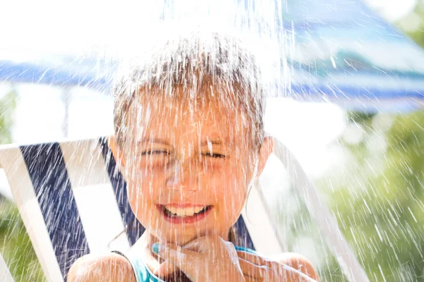 Menina feliz desfrutando no dia de verão e brincando com a água — Fotografia de Stock