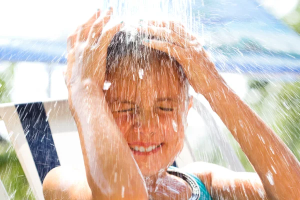 Menina feliz desfrutando no dia de verão e brincando com a água — Fotografia de Stock