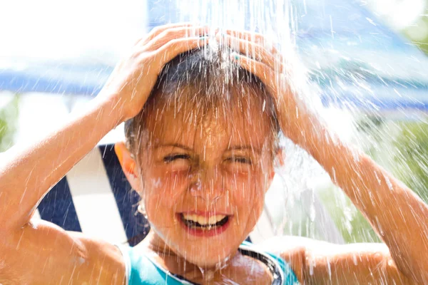 Menina feliz desfrutando no dia de verão e brincando com a água — Fotografia de Stock