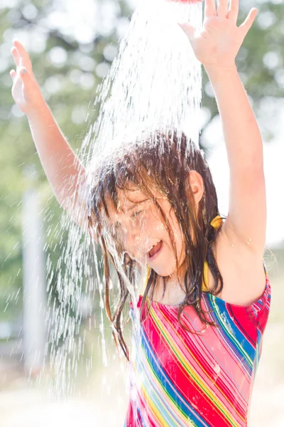 Glad liten tjej njuter i sommardag och leker med vatten — Stockfoto