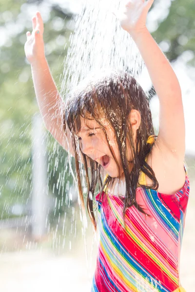 Menina feliz desfrutando no dia de verão e brincando com a água — Fotografia de Stock