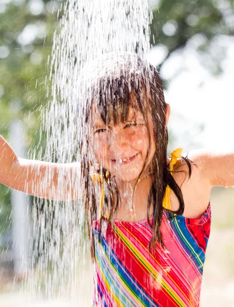 Feliz niña disfrutando en el día de verano y jugando con el agua —  Fotos de Stock