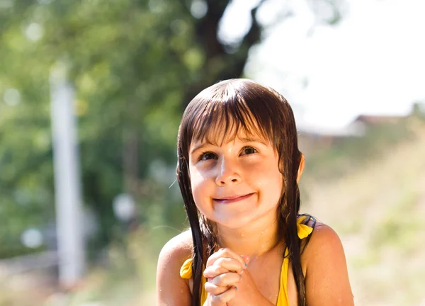 Menina feliz desfrutando no dia de verão e brincando com a água — Fotografia de Stock