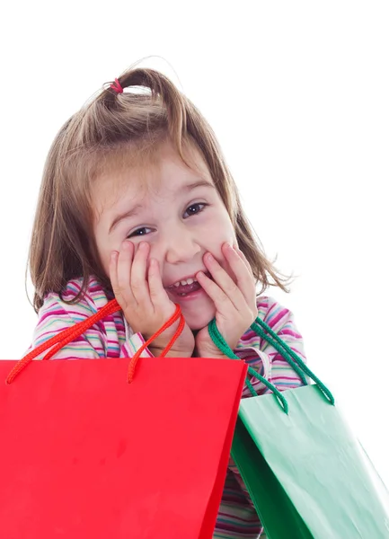 Kleines Mädchen beim Einkaufen mit Warenkorb und bunten Taschen — Stockfoto