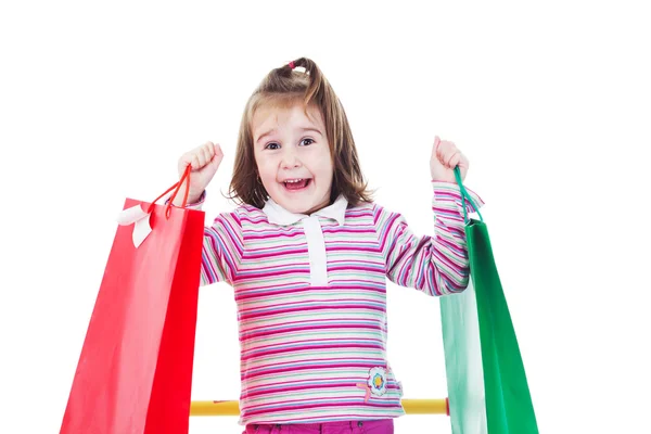 Little girl in shopping with shopping cart and coloured bags — Stock Photo, Image