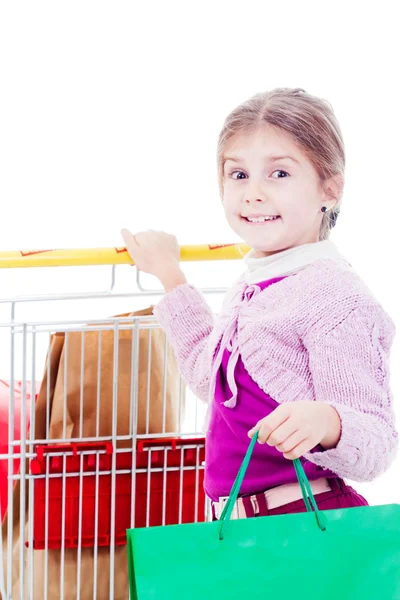 Niña en compras con carrito de compras y bolsas de colores — Foto de Stock