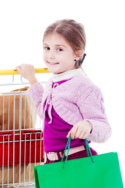 Little girl in shopping with shopping cart and coloured bags — Stock Photo, Image