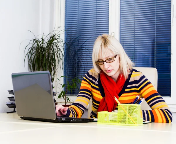 Ung affärskvinna med laptop på skrivbord — Stockfoto